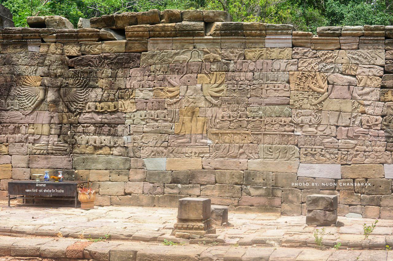 A rare sandstone carving of a standing Buddha with multiple arms on the walls of Banteay Chhmar Temple, showcasing the rich blend of Mahayana Buddhist symbolism and Khmer artistray from the Angkor period.