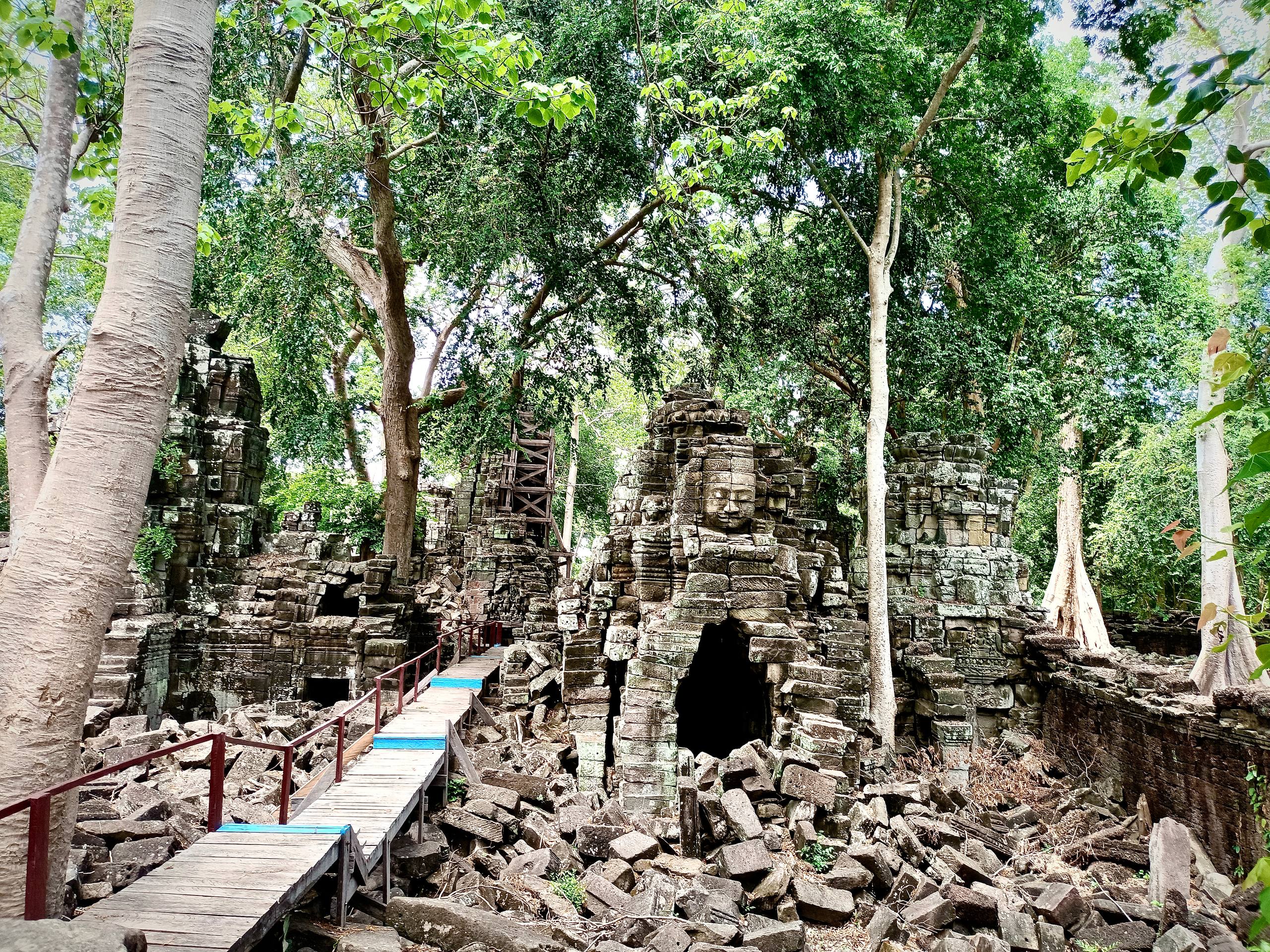 Ancient ruins of Banteay Chhmar Temple embraced by the surrounding jungle.