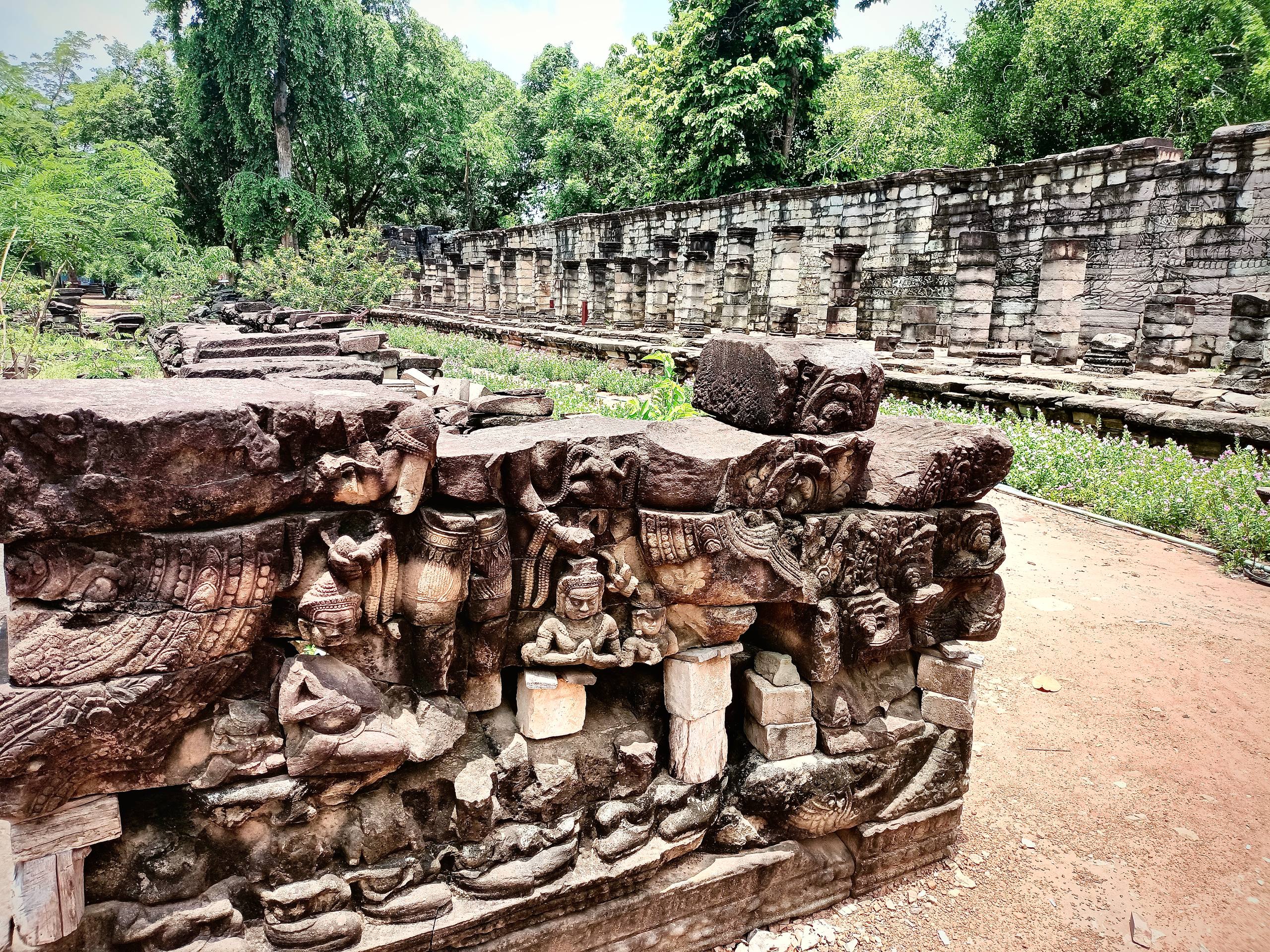 Fallen ancient stone carvings among the ruins of Banteay Chhmar Temple.