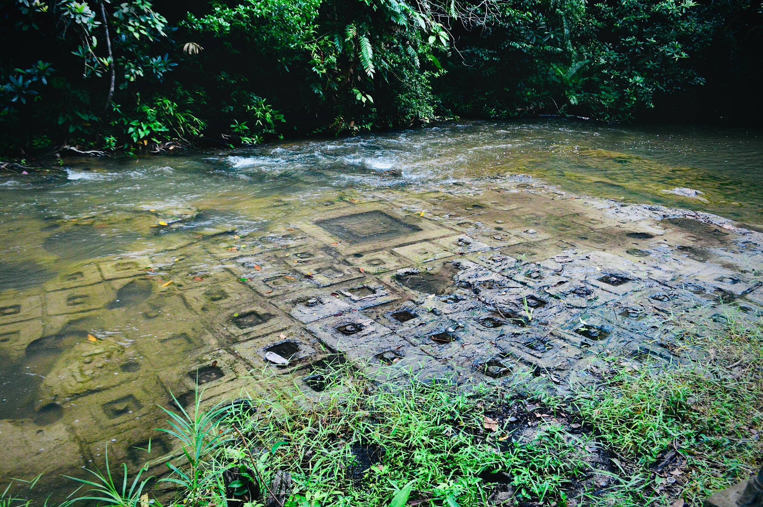 Ancient linga carvings etched into the riverbed at Phnom Kulen, creating the sacred River of a Thousand Lingas.